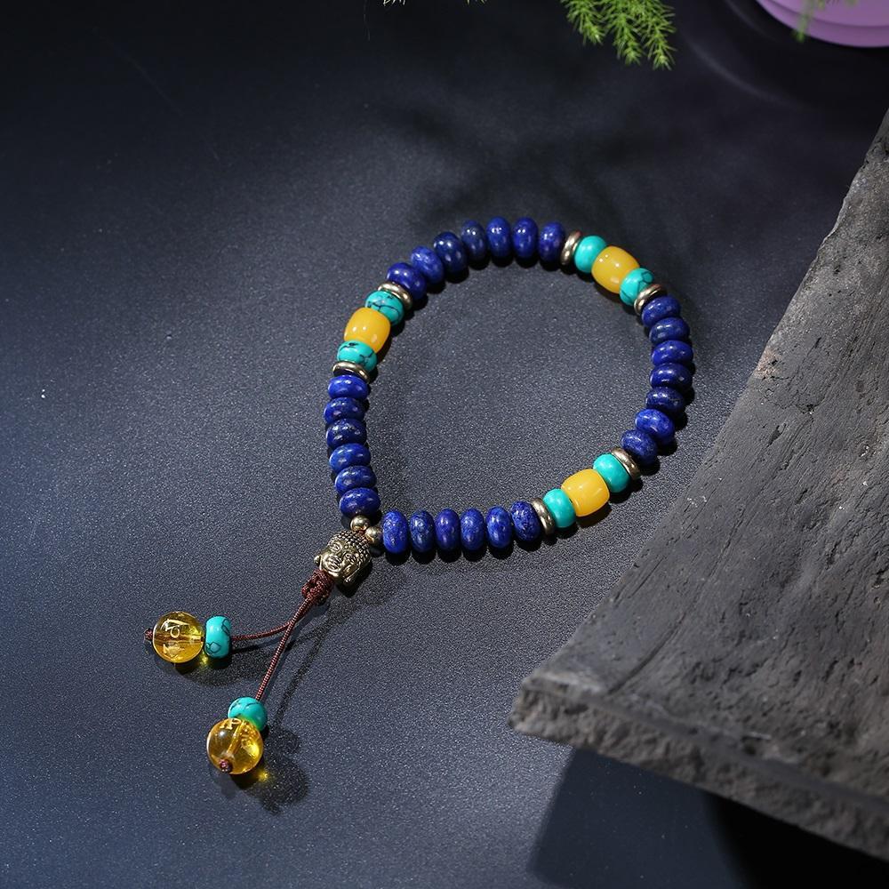 flat-natural-lapis-lazuli-stone-with-6-syllable-mantra-tassel-and-buddha-head-charm-mala-bracelet.jpg Flat Natural Lapis Lazuli Stone With 6 Syllable Mantra Tassel and Buddha Head Charm Mala Bracelet - Image 1